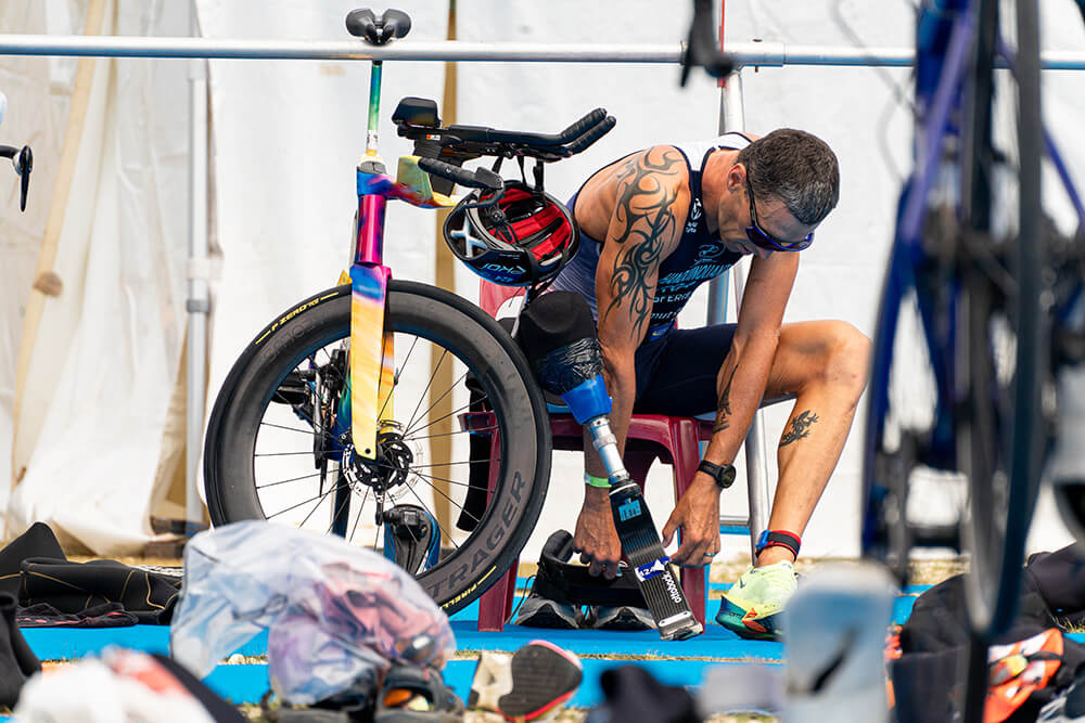 Alexis Hanquinquant, paratriathèlte qui change sa prothèse et s'apprête à courir.